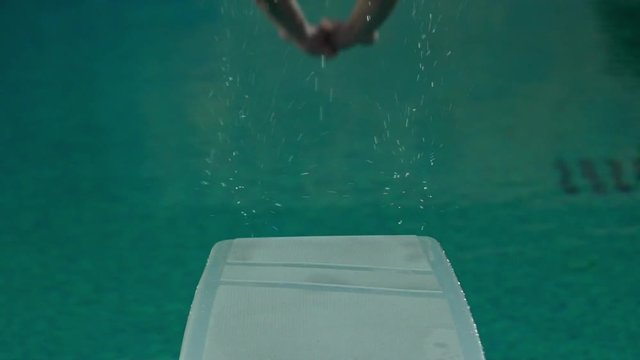 Man jumping from trampoline in the swimming pool.Slow motion. 