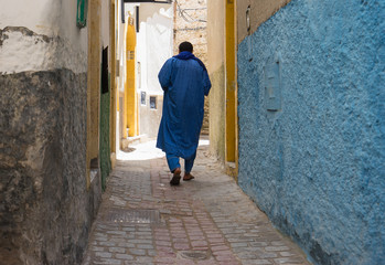Man in traditional arabian closes walking on the street of Essaouira. Morocco.