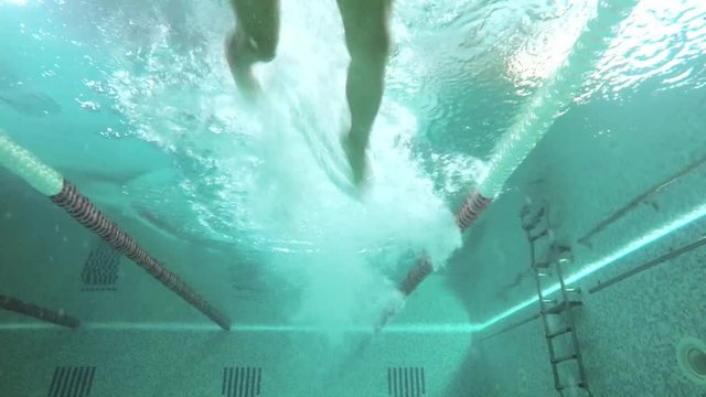 Man swimming in the swimming pool.Slow motion. Underwater view