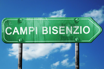 Campi Bisenzio road sign, vintage green with clouds background