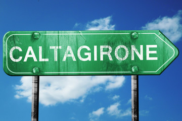 Caltagirone road sign, vintage green with clouds background