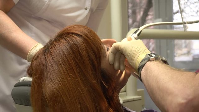 Young Woman in a Chair Dentist Dentistry Procedure, Doctor and Nurse at Work