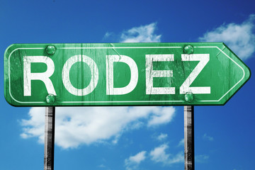 rodez road sign, vintage green with clouds background