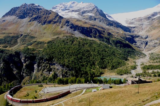 Die Bernina Bahn auf der Fahrt durch die Schweizer Alpen bei der Alp Grüm zum Bernina Hospiz. 