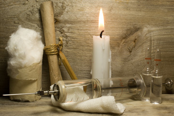 Obraz na płótnie Canvas Iron vintage glass syringe with needles on a wooden background.