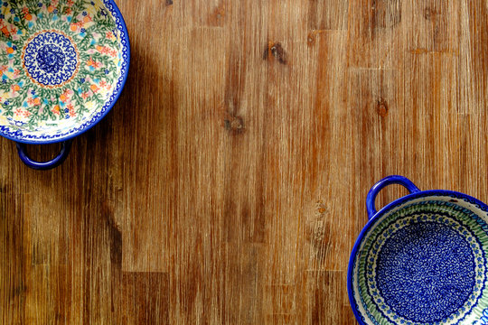 Close-up of vintage plates with colorful ornaments on wooden textured table