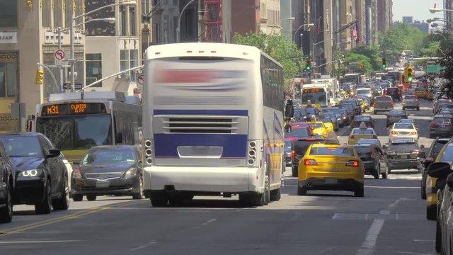 Busy street traffic Manhattan New York City NYC cars buses congested urban sunny day