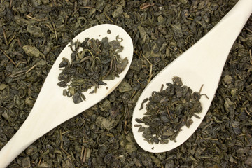 Green dry tea and wooden spoon