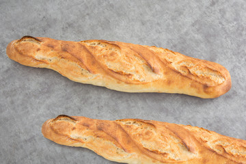 Two french baguettes on a grey background
