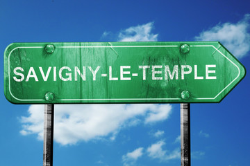 savigny-le-temple road sign, vintage green with clouds backgroun