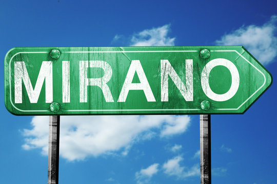 Mirano road sign, vintage green with clouds background
