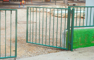 Open gate to playground. Focus is on the ground.