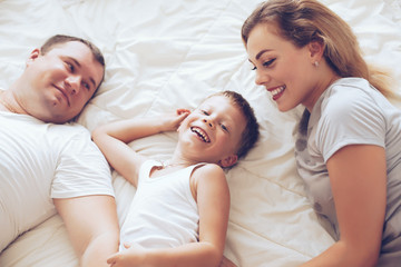 Obraz na płótnie Canvas Happy family relaxing in bed