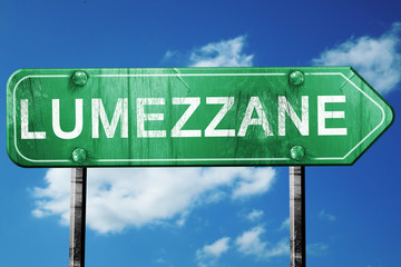Lumezzane road sign, vintage green with clouds background