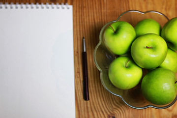 green apple in a glass bowl wooden background
