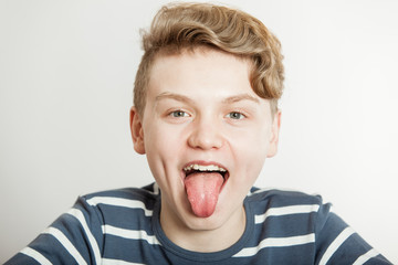 Obraz na płótnie Canvas Young boy sticking out his tongue