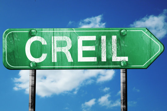 creil road sign, vintage green with clouds background
