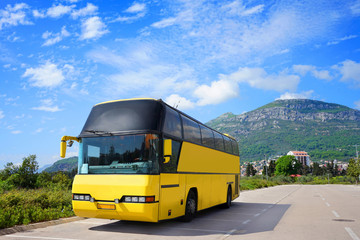 Empty touristic bus is standing on the road near the mountain