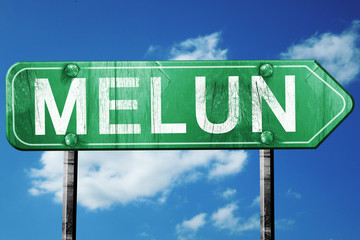 melun road sign, vintage green with clouds background