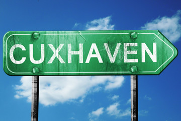 Cuxhaven road sign, vintage green with clouds background