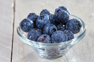 Fresh blueberries with water drops in a glass bowl
