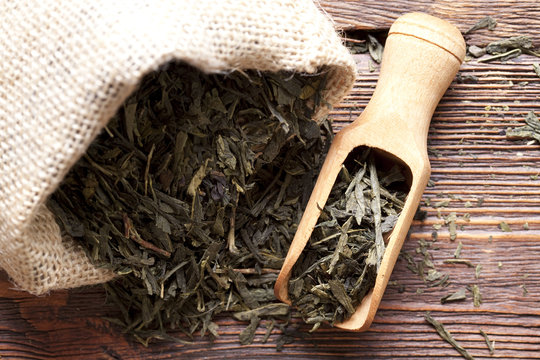 Dried Tea Leaves In Jute Bag On Wooden Planks