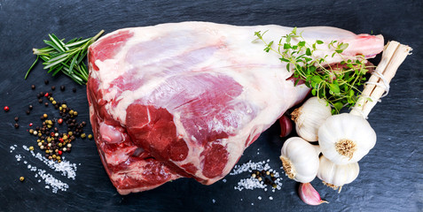 Raw lamb leg on blue stone background