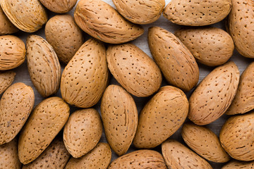 Group of almond nuts with leaves.Wooden background.