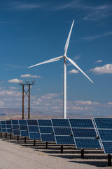 Solar panels and wind turbines in sunny desert
