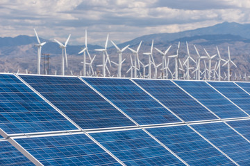 Solar panels and wind turbines in sunny desert