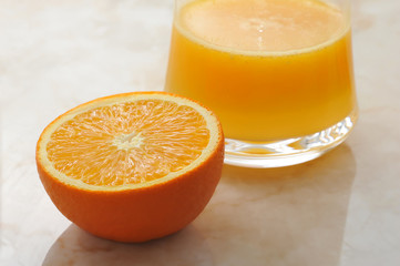 half orange and a glass of freshly squeezed orange juice