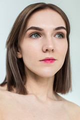 Beauty portrait of young model with middle length hair. Professional nude makeup. Green eyes.