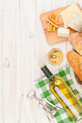 Fototapeta na wymiar White wine, cheese and bread on white wooden table background