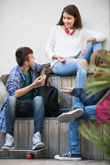 Three teenagers hanging out outdoors