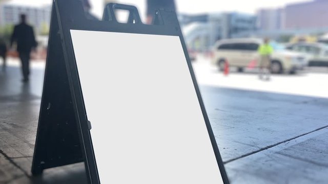 A Blank Sign On A Sidewalk Outside Of A Convention Center.  	