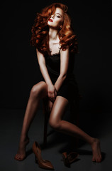 Beautiful red haired woman relaxing in black silk peignoir, take