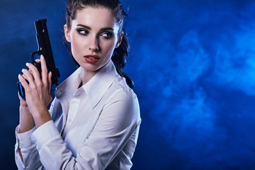 beautiful sexy girl holding gun . smoke background