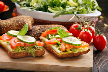 Vegetarian sandwich with pesto on wooden background