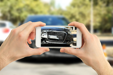 Man photographing his car with damages
