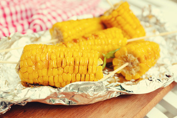 Grilled corn cobs on table, close-up. Retro style