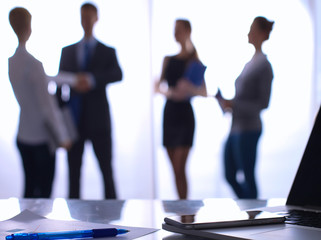 Laptop  computer on  desk ,  businesspeople standing in the background
