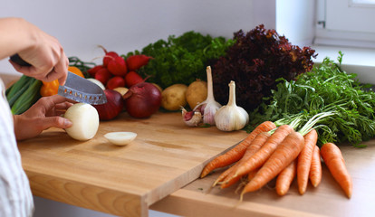 Young woman cutting vegetables in the kitchen
