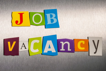 The word Jobs  Vacancy in color cut out magazine letters on metal background. Hiring concept
