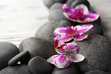Obraz na płótnie Canvas Spa stones and orchids on wooden background