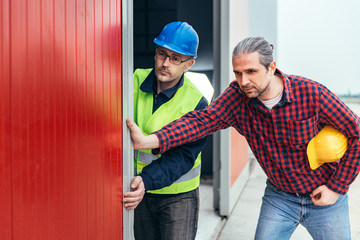 Construction workers opening hangar door