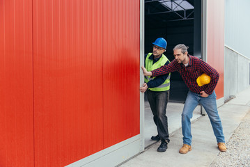 Construction workers opening hangar door