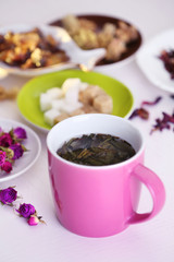 Cup of tea with aromatic dry tea on wooden background