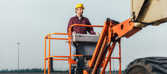 Worker operating Straight Boom Lift