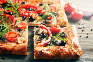 Freshly homemade pizza on wooden table closeup