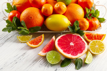Set of different citrus fruit on light wooden background